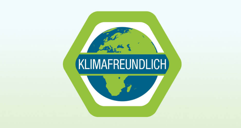 A hexagonal badge with a blue and green globe in the center, featuring the text "Klimafreundlich" in white.
