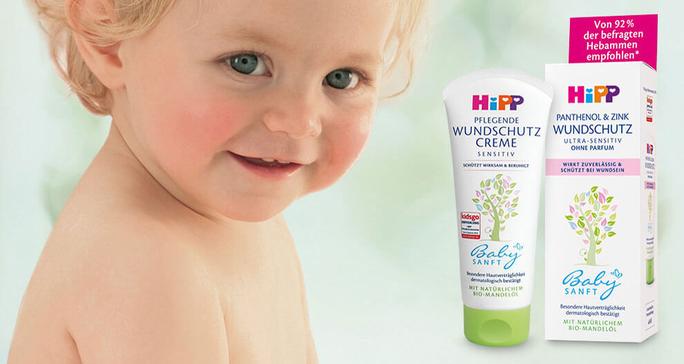 A young child is juxtaposed with a tube of baby cream and its packaging, which are labeled in German.