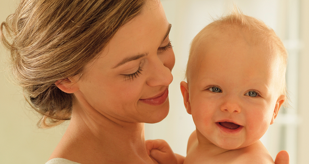 A woman lovingly holds a baby.