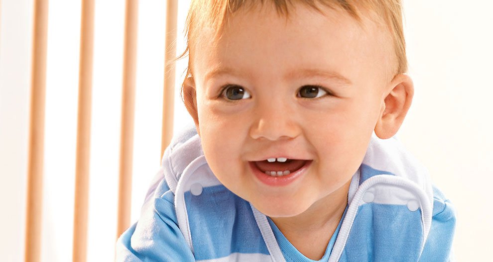 Baby in blue and white striped shirt, smiling.