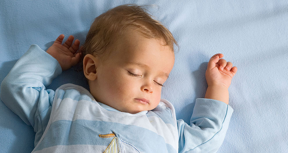 Baby sleeping on a blue bed.