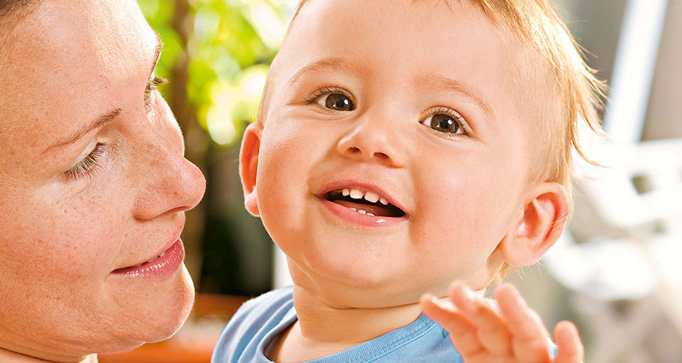 A woman and a baby share a close moment.