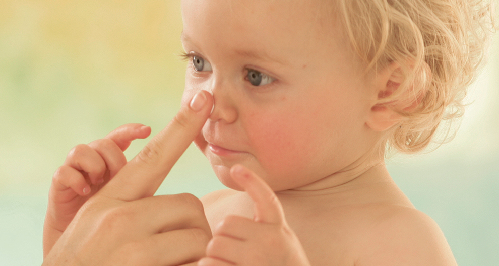 Child, hand, nose, fingers, close-up, soft focus.
